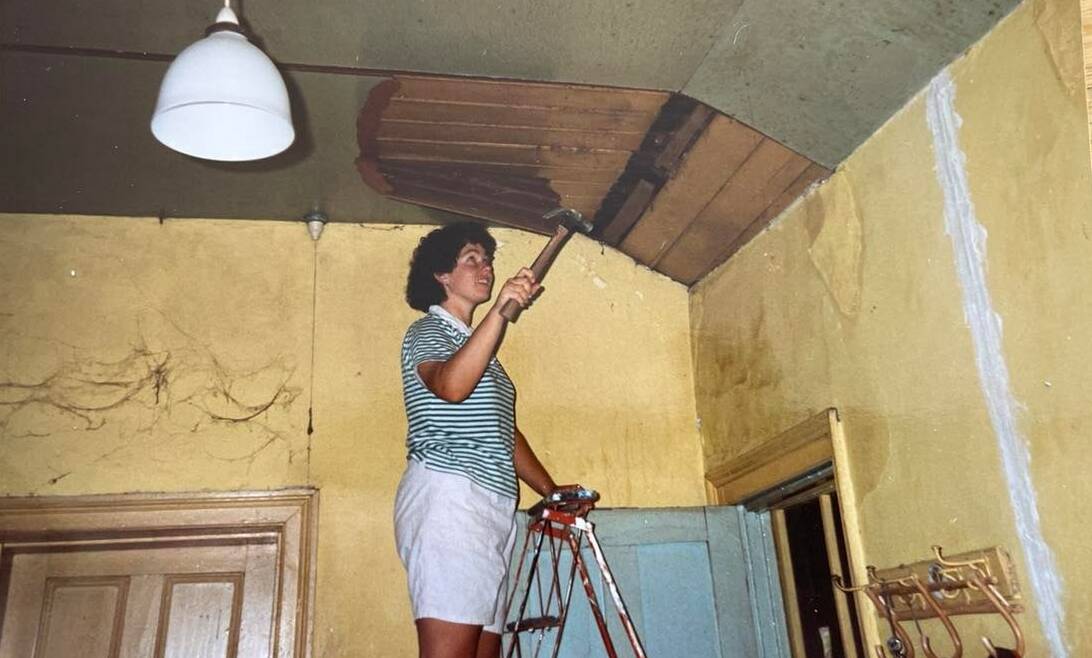 Susan Butt up a ladder during the Yass restoration project in 1987. Photo: supplied