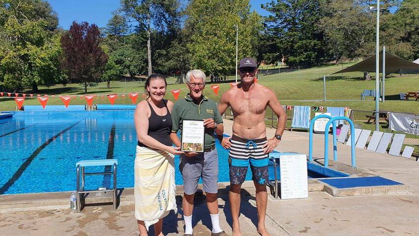 Zoe and Mark Philipzen receiving the certificate from Can Assist on behalf on the marathon swimmers.