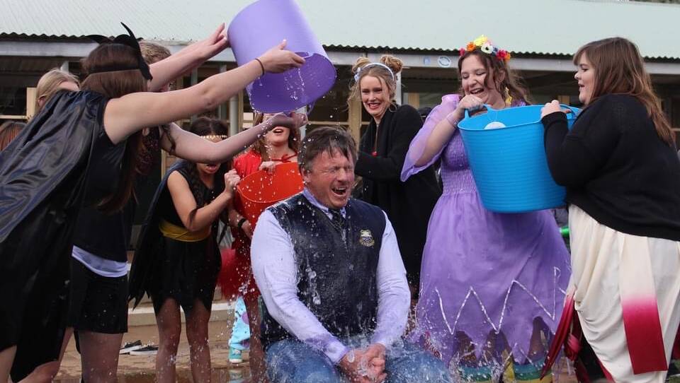Adrian Bell taking part in the ice bucket challenge with the help of students at Monaro High School. Photo: supplied