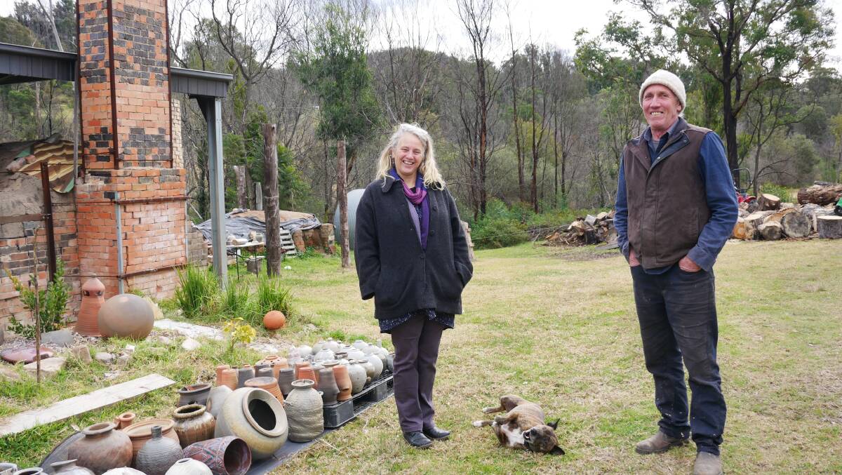 Gabrielle Powell and Daniel Lafferty with their dog Bruno on their property where they run Bandicoot Pottery in Cobargo. Photos: Ellouise Bailey