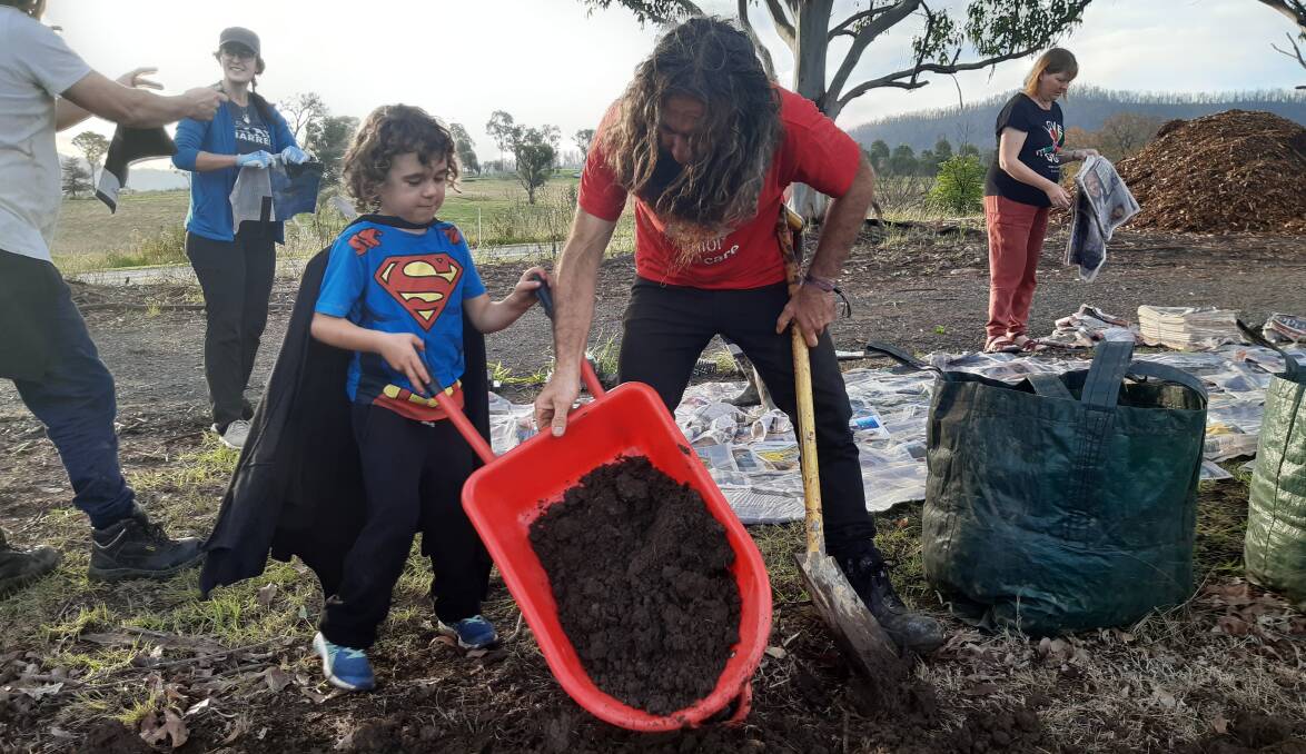 Costa Georgiadis and a local child empty a wheelbarrow together at the working bee on Saturday May 8 at Cobargo Preschool. Photos: supplied 