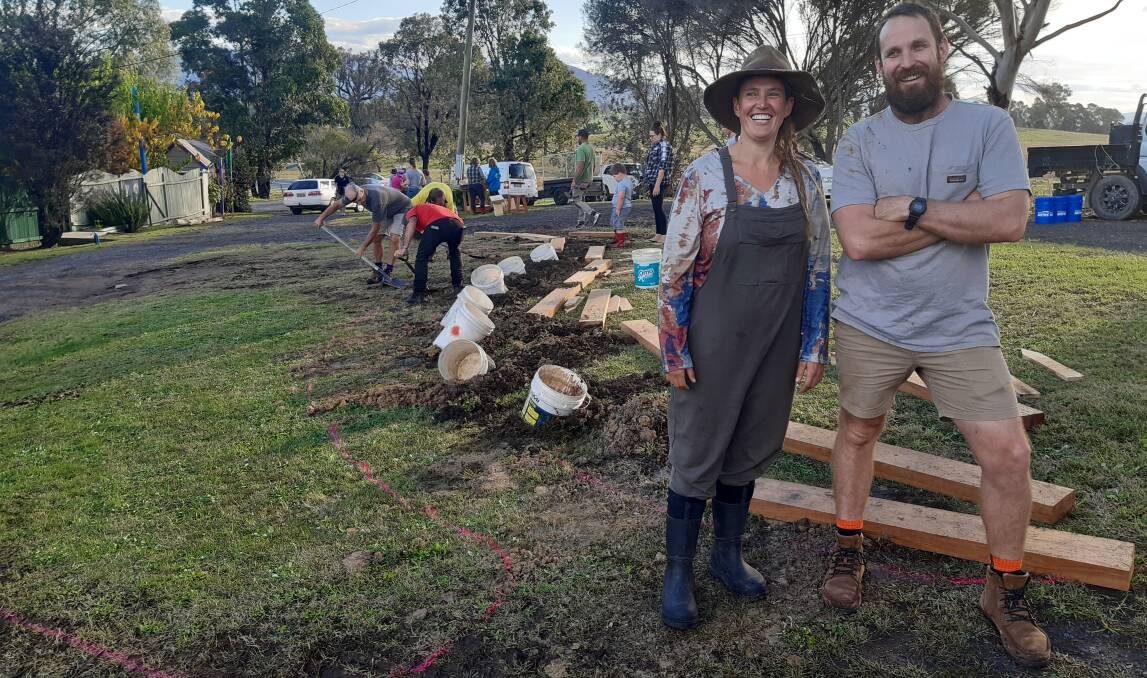 Earth builder Kate Ogden with Paul West in front of the holes where posts were erected. A community member excavated the 15 holes prior to the workshop ready for the working bee. 