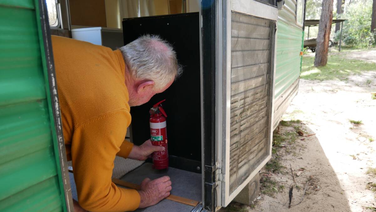 Geof Maher installing a fire extinguishing to the current caravan he has been working on, his 79th caravan to date. Picture: Ellouise Bailey