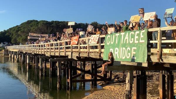 Residents opposed to the demolition of Cuttagee Bridge, as it stands in place for a two-lane concrete bridge, gathered with placards on the bridge. Photo: supplied
