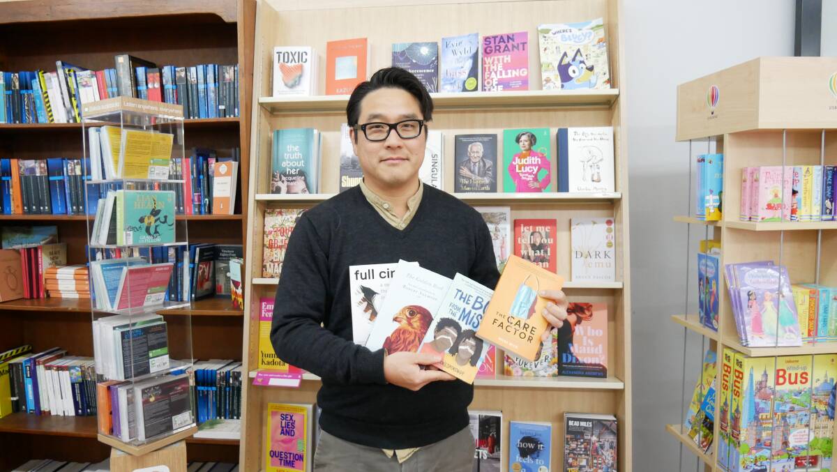 Owner of Candelo Books Myoung Jae Yi holding a selection of books from authors featured in the festival line-up. Photo: Ellouise Bailey