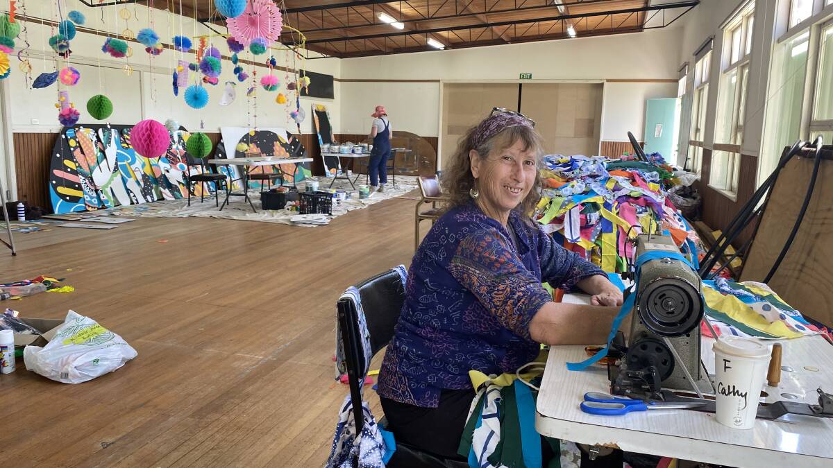 Volunteer Kathy Koukoumaftis uses her sewing skills at a studio in Bega to work on decorations for Pambula's Wanderer Festival. Picture supplied