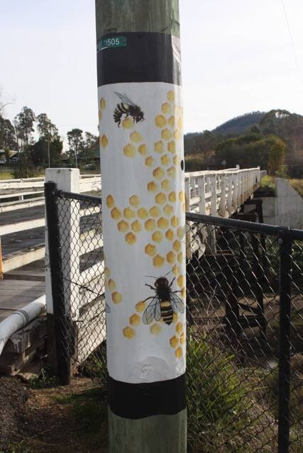 One of the poles featuring bees to a hive by artists Ros Hewett. Photo: supplied