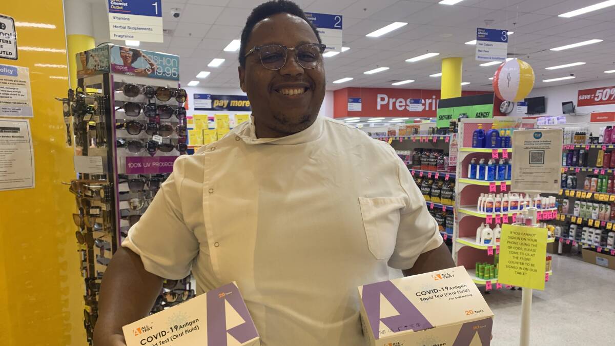 Pharmacist in charge Freddy Kagonda holding boxes of rapid antigen tests outside Direct Chemist Outlet in Sapphire Marketplace, Bega. They were sold out within hours of arriving. Photo: Ellouise Bailey