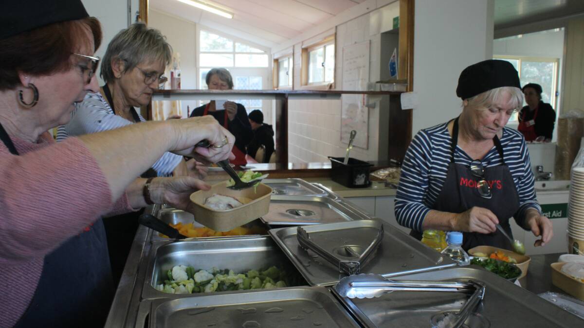 Volunteers Robyn Bennett, Robin Scott-Charlton and Rhonda Noormets in the kitchen production line serving meals at Monty's Place at lunchtimes on Wednesday. File picture