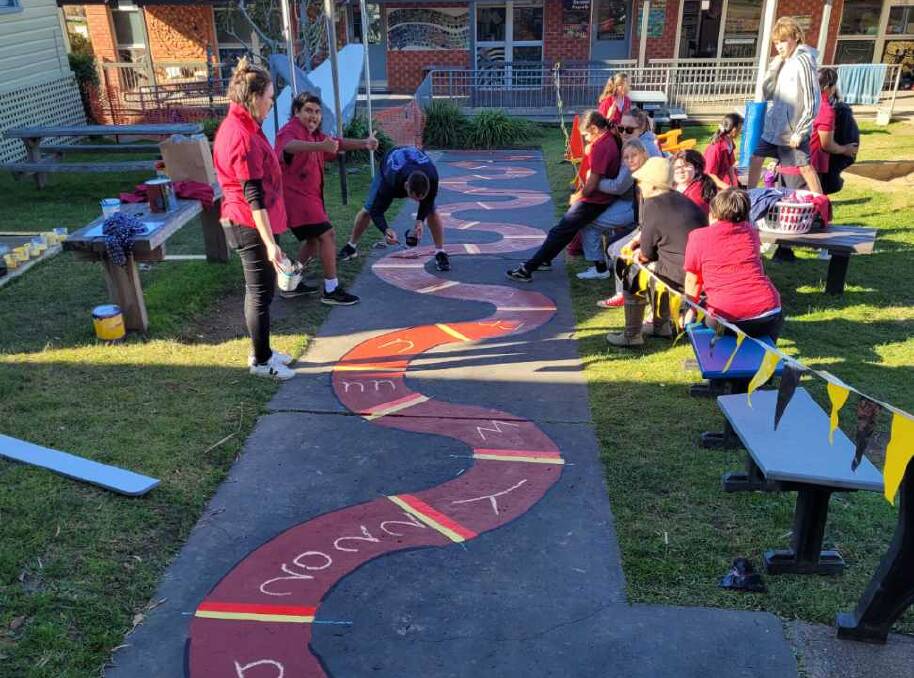 Students giving the painted snake in the school's courtyard a new lease of life