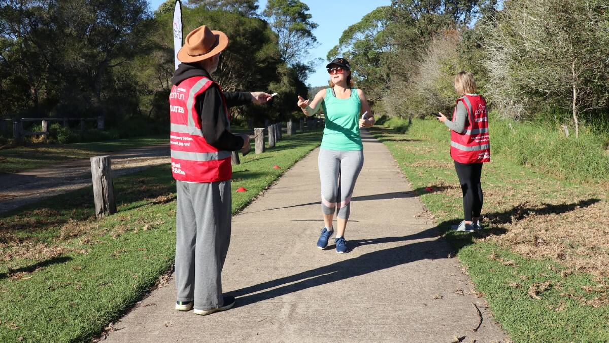 Alec McQueen handing out finisher tokens at a recent event. Picture supplied by Panboola Wetlands parkrun Facebook. 