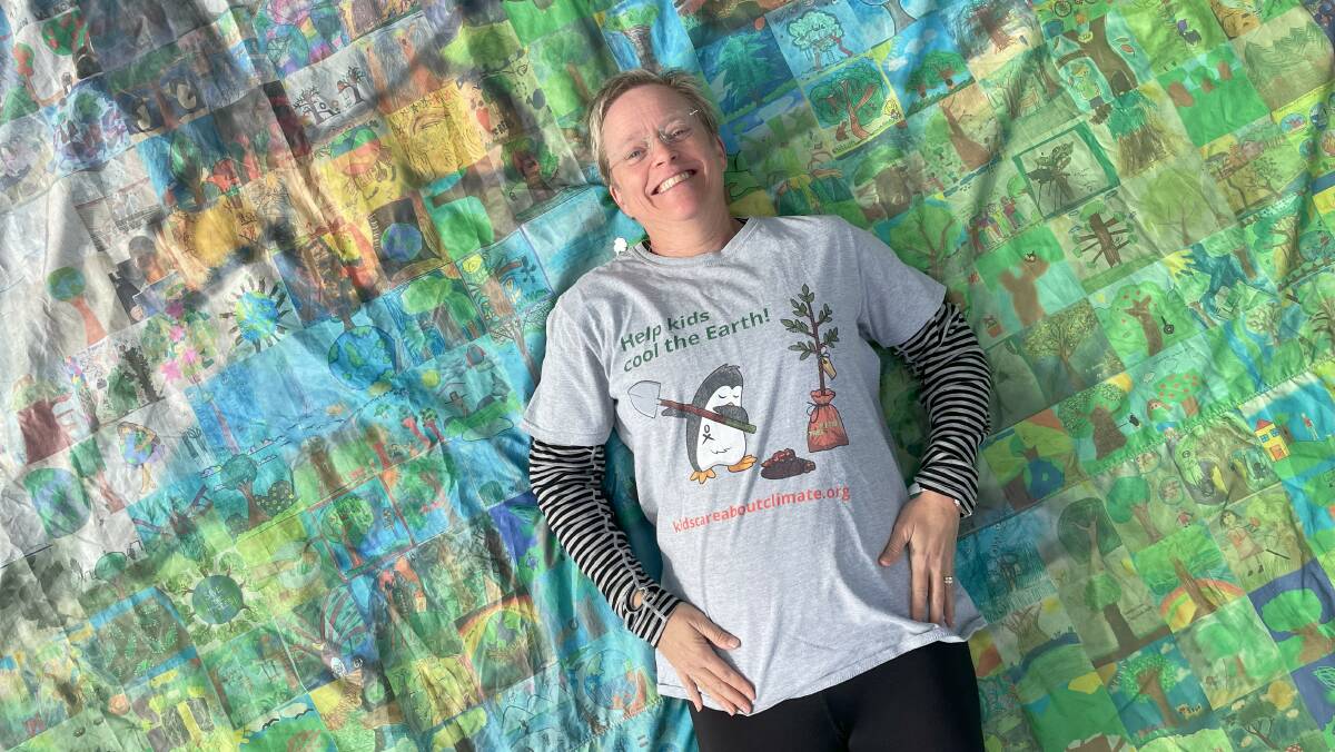 Marine biologist Dr Marji Puotinen with the collaborative art banner with the logo of a dabbing penguin (dabbing is a dance gesture that became popular in 2015). Picture by James Parker