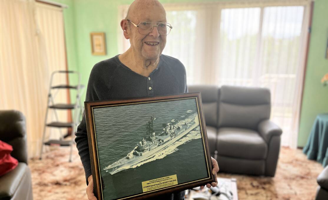 Darrell Hegarty with an image of HMAS Perth II mounted with a plaque which he received for his service. Picture by James Parker