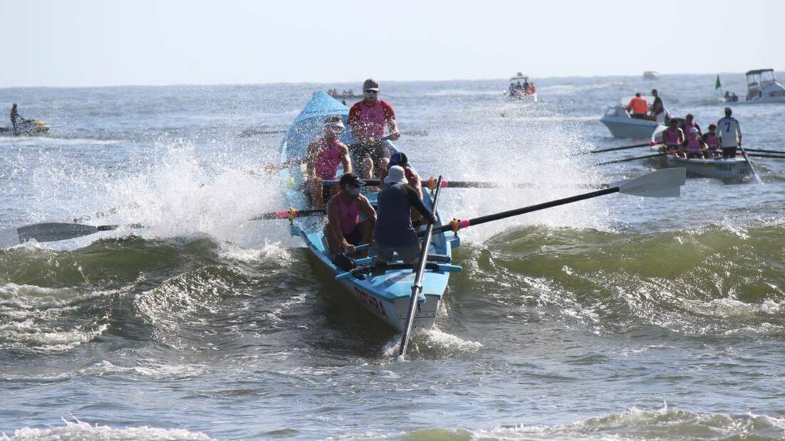 The Tathra men's crew make a splash launching off Merimbula in a previous George Bass Surf Marathon.