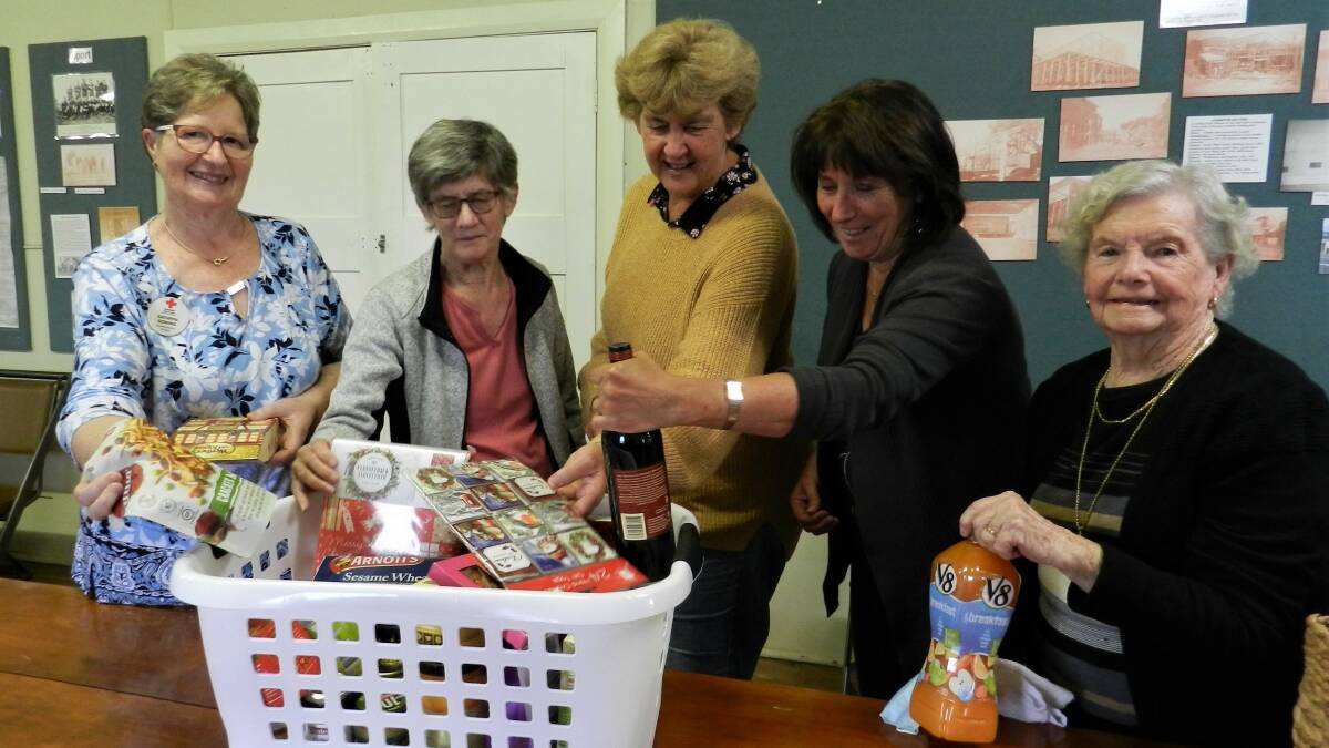 Wolumla Red Cross members prepare a hamper in readiness for the Christmas Raffle. They will be selling tickets in Bega, Tura, Wolumla, Merimbula, Tathra and Pambula. 