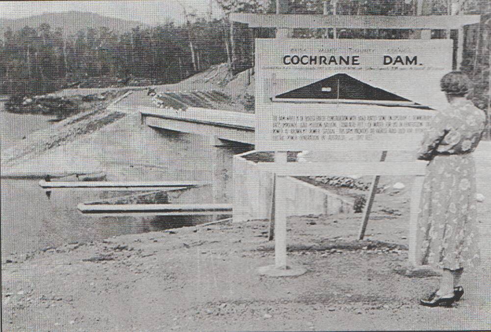 LOOKING BACK: A resident reads a sign next to the Cochrane hydro-electricity dam. It was completed near Bemboka in 1958. Picture: Supplied