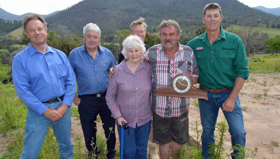 An emotional day at Bemboka as Diana Armstrong is gifted her antique clock thought lost in the bushfires, lovingly restored by Barry McAlister. Also pictured are Tony, Graham and Sean Armstrong, and Mick Keys. Photo: Ben Smyth
