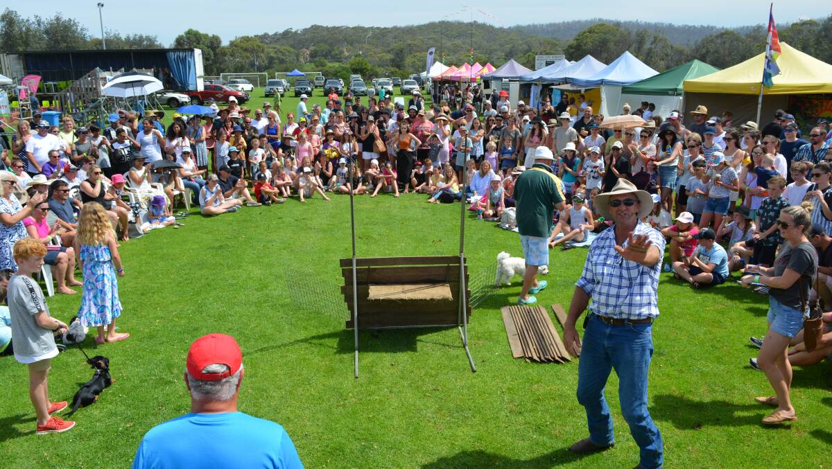 Popular dog high jump organiser Brett Rogers winds up the crowd at the recent Pig Day Out at Tathra.