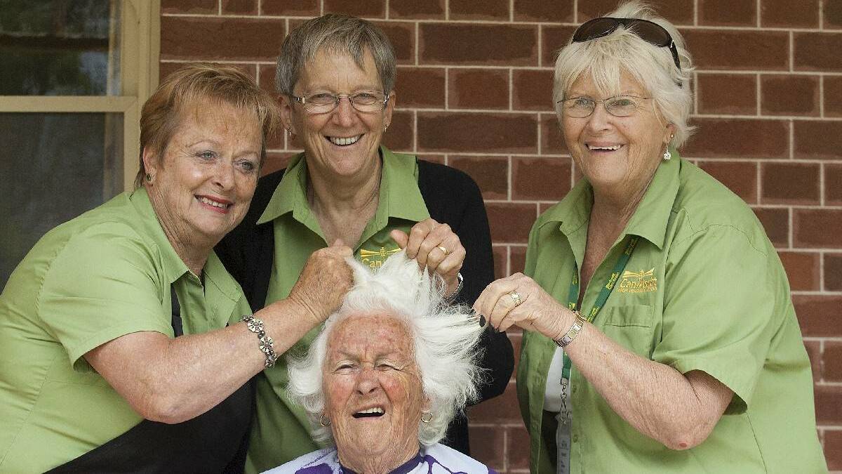 Beth Collins (middle) in one of Bega Valley Can Assist's fun fundraisers in 2013 - shaving Shirley Watson's head.