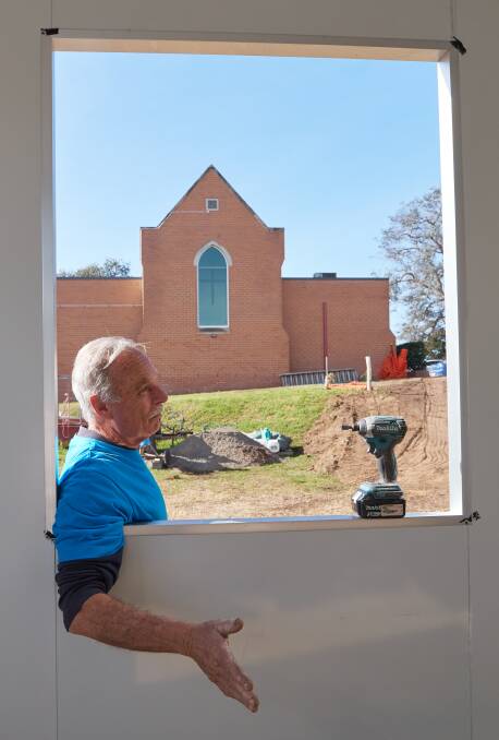 Mick Brosnan of the SJA looks over one of the units being installed behind the Bega Uniting Church. Photo: David Howard