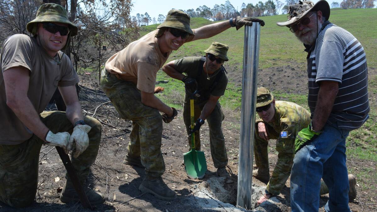 Response Team 3 Army personnel give Greg Chinnock a hand rebuilding his boundary fence near Quaama. Photo: Ben Smyth