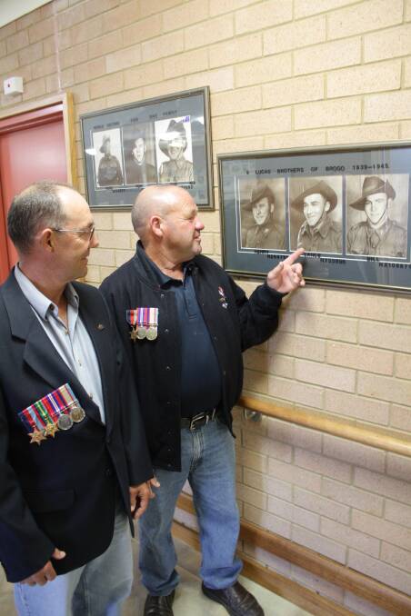 In this BDN photo from 2010, Geoffrey (Hedley) and Henry Lucas, proudly wearing their father’s medals, admire a  photo of their dad, Lance.