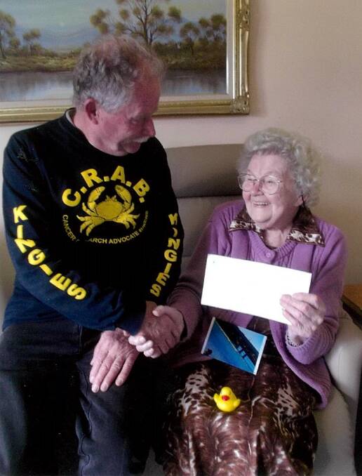 Hans Wiedeman from CRABs congratulates Eden resident Petronella Piet, 92, for her first prize in the Bermagui Duck Race.