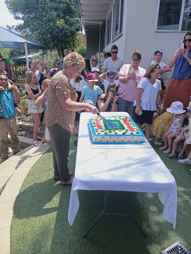 Sue Grant, who was officer manager of Bega Preschool for 29 years, cuts the cake at Saturday's 50th anniversary celebration.