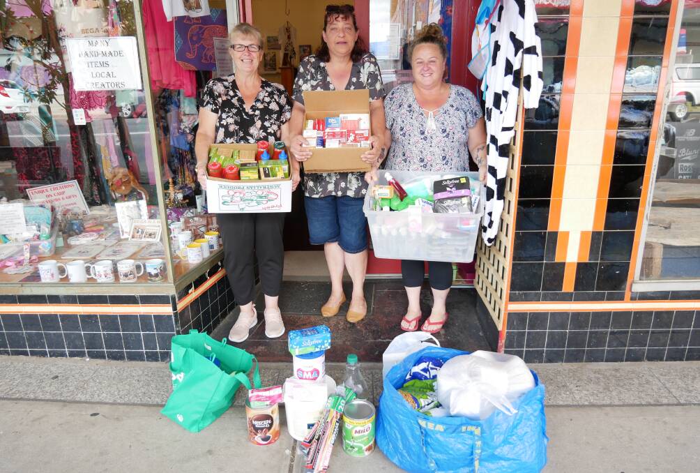 YOU CAN HELP: Karyn (Ducky) Radford, Cheryl Robinson, and Sharon Smith stand outside of Cheryl's shop at 239 Carp Street with a tiny portion of the donations collected over the week for flood-affected victims. Photo: Ellouise Bailey