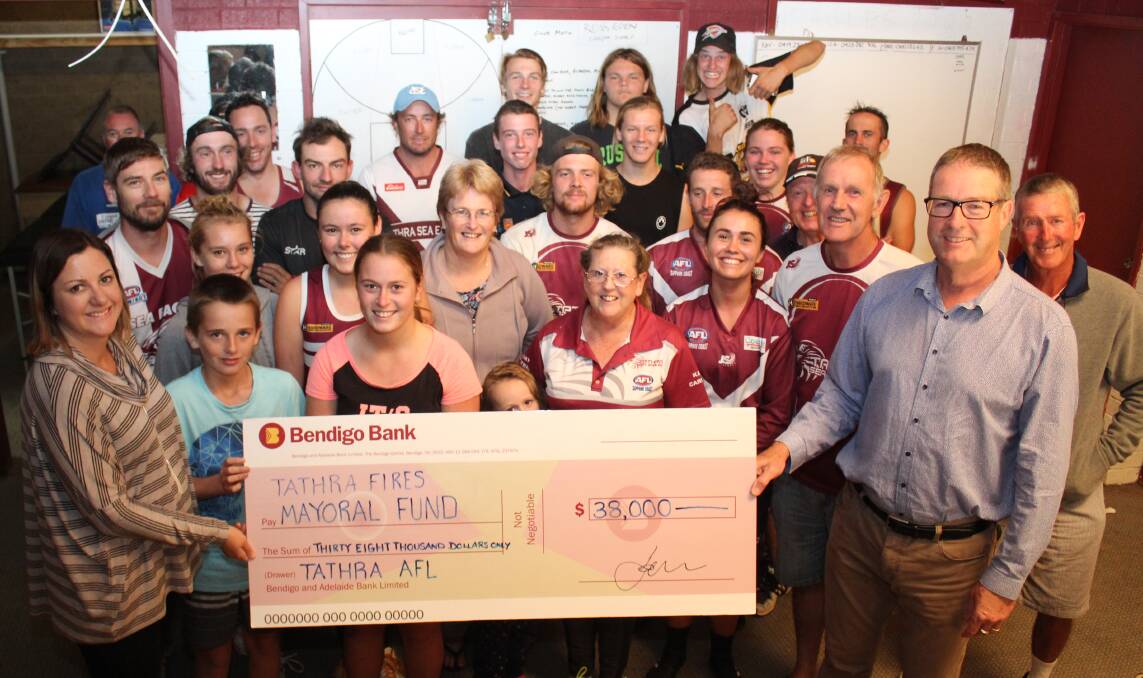 The Tathra Sea Eagles Aussie Rules Football Club present Bega Valley Shire Mayor Kristy McBain with the $38,000 raised during a recent bushfire fundraiser event. Picture: Ben Smyth