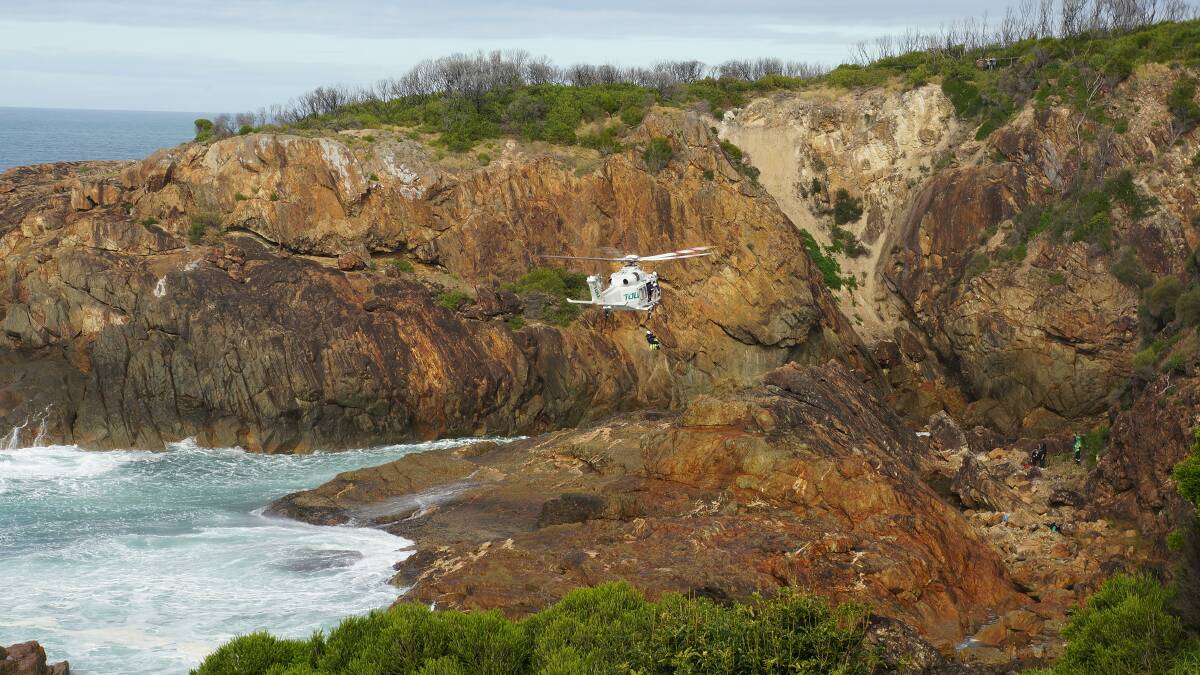 Toll SouthCare Rescue helicopter winches a rock fisherman to safety at Tathra Headland on June 18. Photo sent in by Col Goodacre
