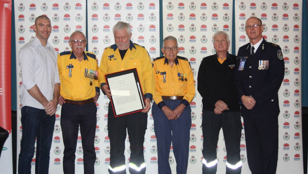 RFS Deputy Commissioner Kyle Stewart APM and Eurobodalla Shire Mayor Matthew Hatcher present Captain Berkeley Braham, President David Beare, former Senior Deputy Captain Pat Harris and past President Peter Anderson with a Commissioners Certificate of Commendation for the Malua Bay Rural Fire Brigade
