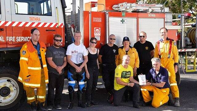 Roy Fisher and his fellow Canberra motorbike riders hand over a collection they organised to the Tathra Rural Fire Service.