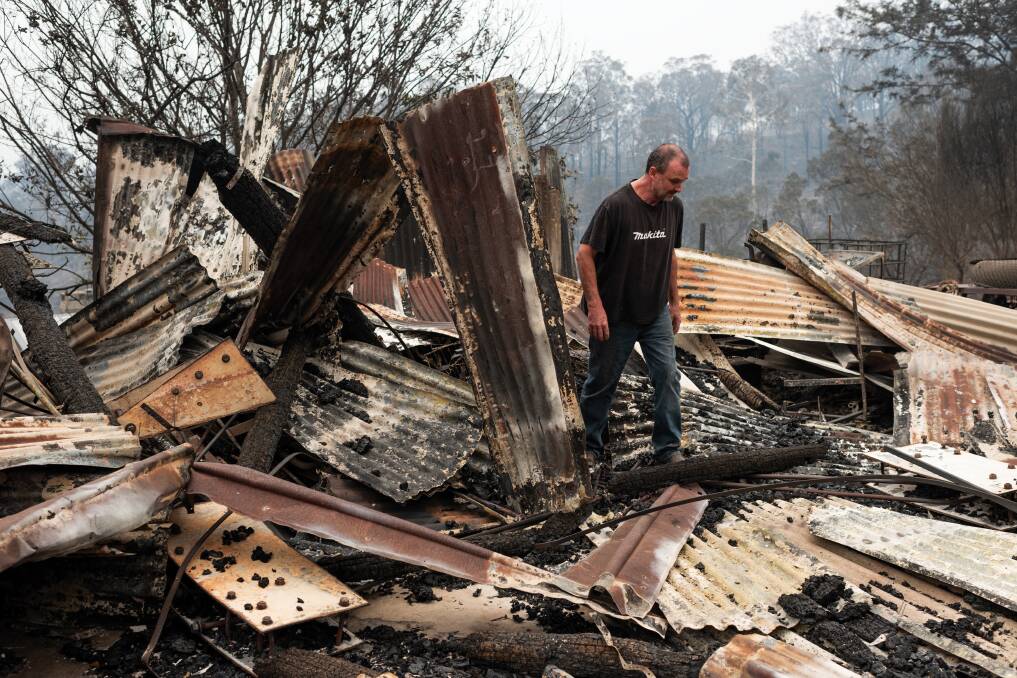 Peter White walks through the wreckage of his shed on New Buildings Road, February 2. His house was saved by the Wyndham RFS.