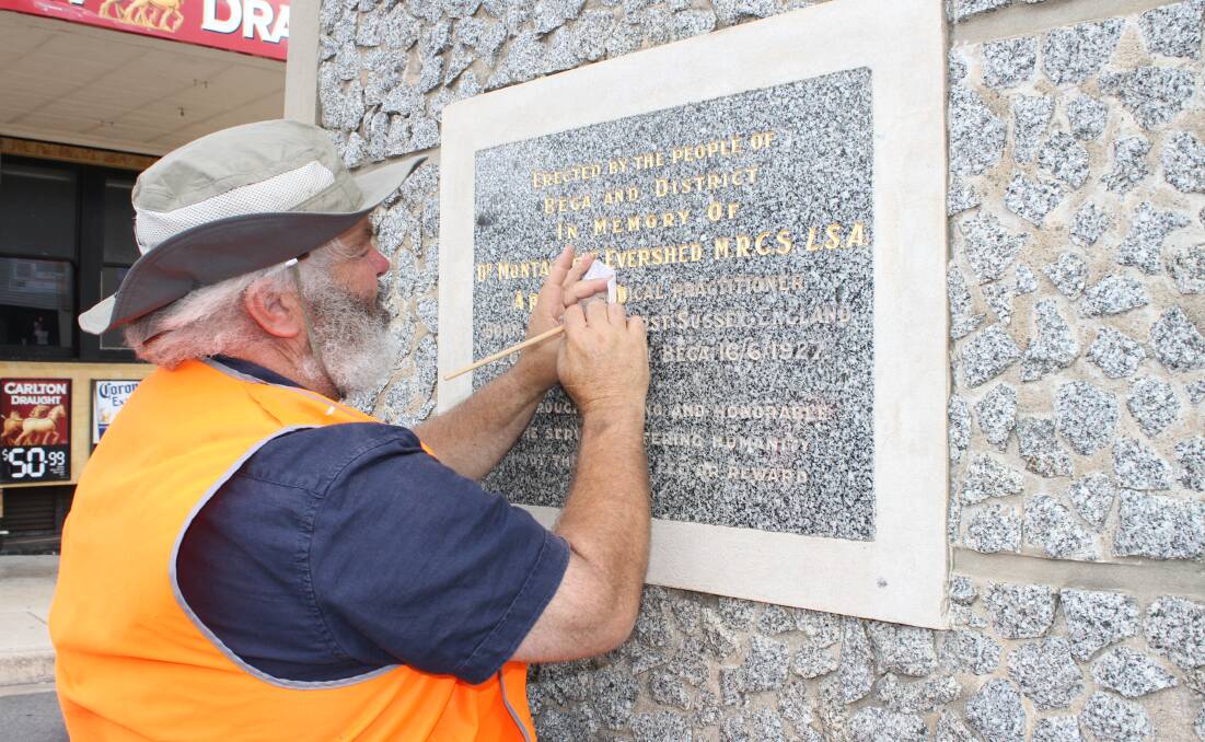 GOLDEN TOUCH: Design Post's Danny Kaye places gold leaf on the Bega clock tower's plaque commemorating the life of Doctor Montague Evershed 