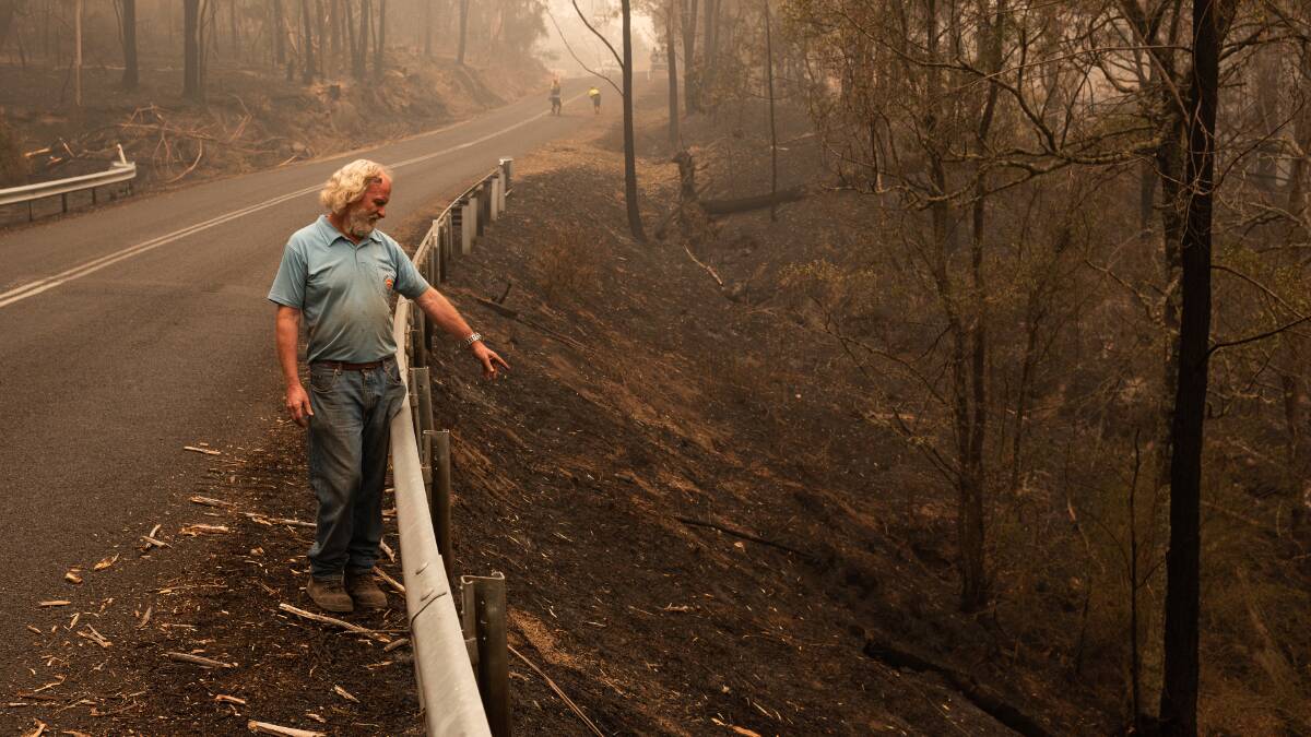 James Smith points to the suspected point of ignition for the Myrtle Mountain Road bushfire, on the other side of the road to his property, Wyndham, NSW, January 2, 2020. Photo Michael Weinhardt