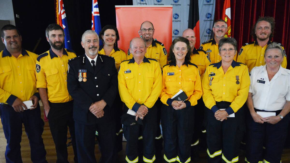 HIGH HONOURS: Superintendent Angus Barnes (third from left) and members of the Merimbula Rural Fire Brigade upon awarding of their National Emergency Medals. Photo: Ben Smyth