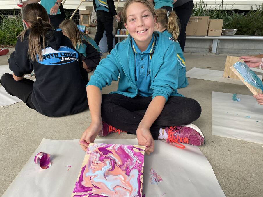 Wolumla Public School student Kiara Rosseland shows off some of the wonderful artwork to be sold at Friday night's fireworks and market extravaganza.