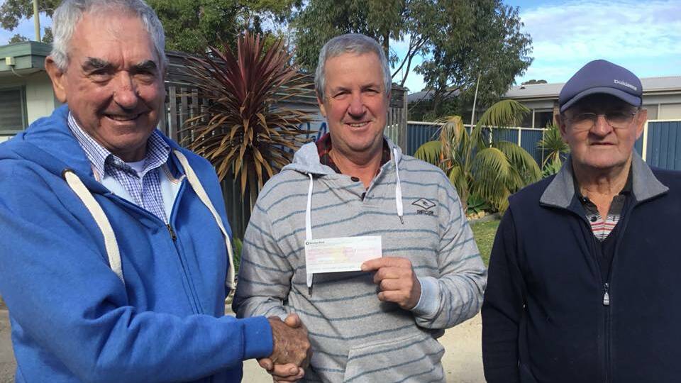 Bryson Banfield from Bega Lions is presented a cheque for $1000 from Mallacoota Lions Max Donovan and Gary Warren, to go towards stage 2 of CCASE