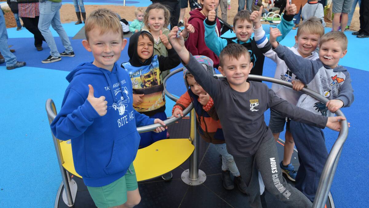 IN A SPIN: Children enjoy the new equipment at Tathra's redeveloped Lot Stafford All-Abilities PLayground. Photo: Ben Smyth