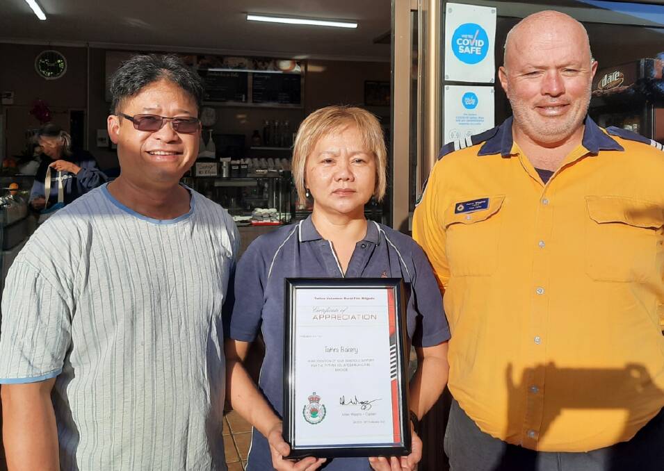 APPRECIATION: Joe and Quyen Nguyen are thanked for their community fundraising efforts by Tathra RFS captain Adam Wiggins. Photo supplied