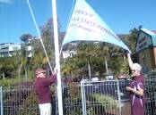 Club patron Col McCrae and team president Mary Tupper raise a flag at Tathra Beach Bowling Club celebrating the women's team recent state pennant win.