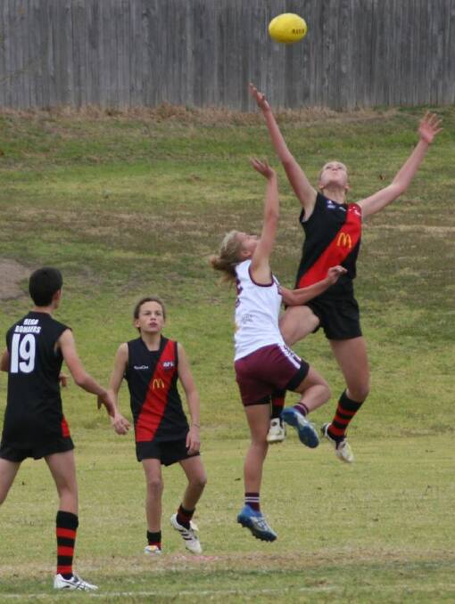 HIGH-FLIER: Amelie Gautier leaps in the ruck over a Tathra opponent earlier this year. She has been selected to train with the South East Sports Academy.