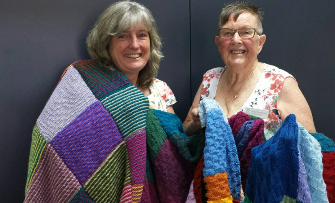 Merimbula Evening VIEW member Margaret Speight has been busy knitting colorful rugs for the carers accommodation in Bega, presented to Lynne Koerbin.