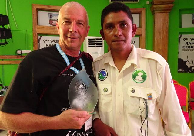 Ranger and chair of the Protected Area Workers Association (PAWA) George Malolakis receives a plaque of gratitude from Peruvian Ranger president Werhner Montoya at the 9th World Ranger Congress in Chitwan, Nepal for aid and assistance provided by PAWA to Peruvian Rangers.