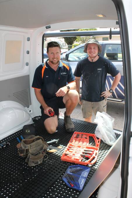 Plumbers Brad McBain and Joel Tamatea install fittings for a washing machine into the Australian Community Media mobile laundrette. Photos: Ben Smyth