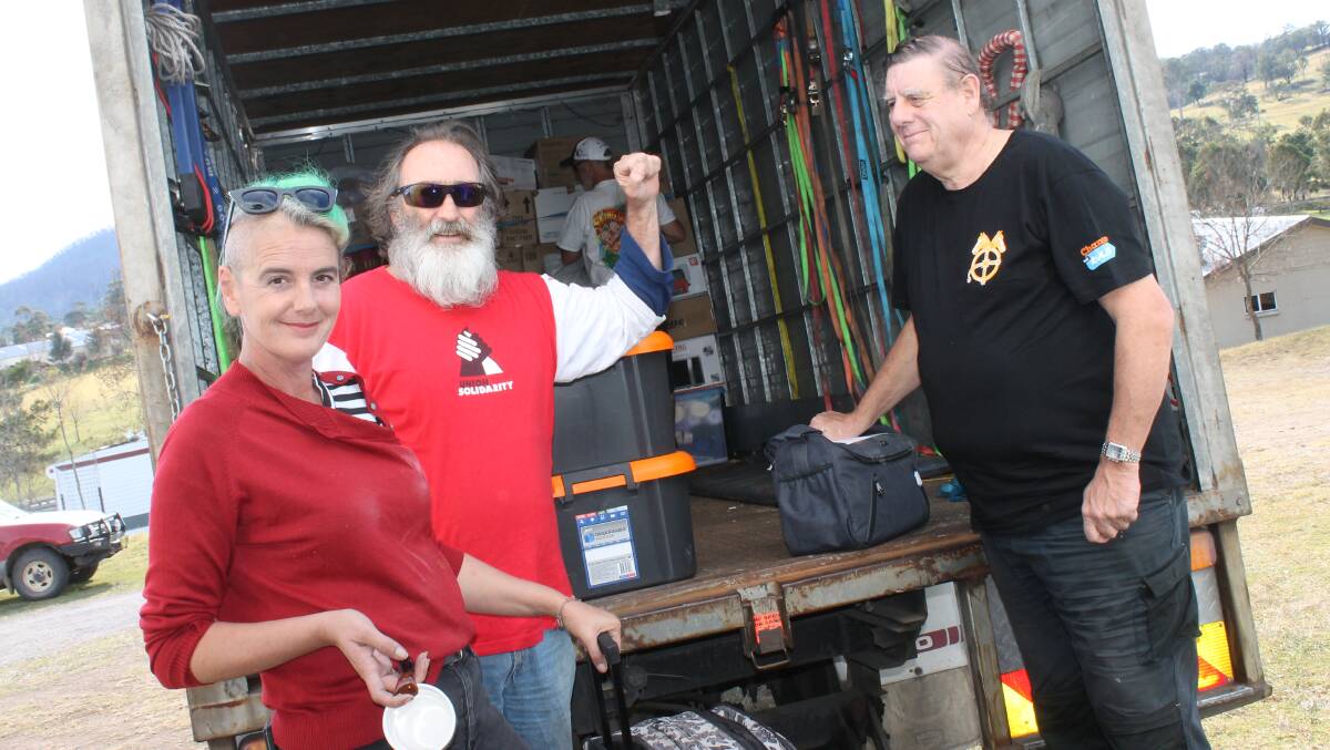  Cobargo Bushfire Relief Centre's Danielle Murphy and volunteer Andrew Olsson unload the truck on Wednesday with TWU's Guy Wernhard.