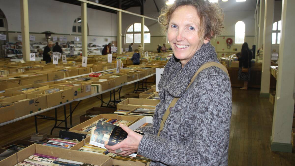 SEARCHING: Tathra's Jani Klotz browses the Rotary winter book fair to replace ones lost during last year's tragic bushfire. Picture: Alasdair McDonald