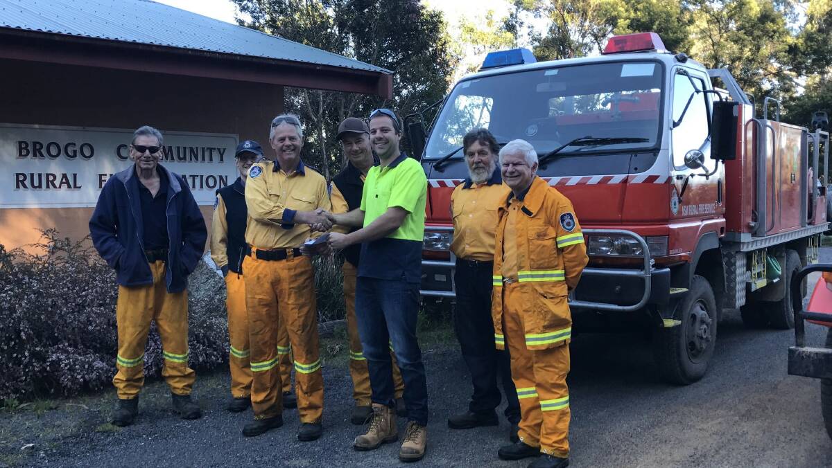 ASSISTANCE: Matthew McKinnon from Cyneve presents a cheque for $1500 to Brogo RFS brigade captain Mike Jay.