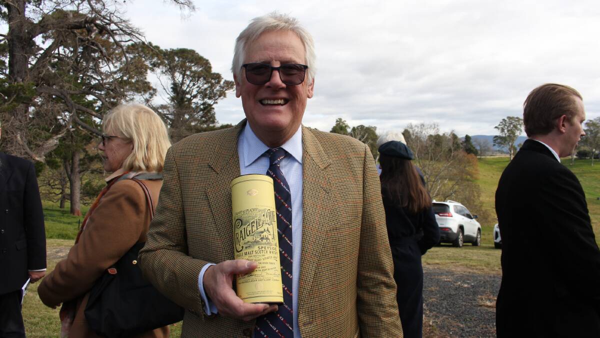 Christopher Koren, who gave the eulogy, with the case containing the last drop of scotch he had shared with his friend Frank Foster. Photo: Denise Dion